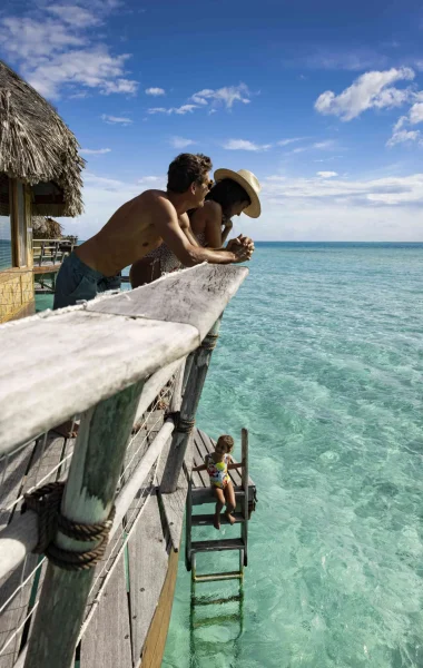 Un couple qui apprécie la vue depuis leur bungalow sur pilotis à Taha'a©_Grégoire Le Bacon